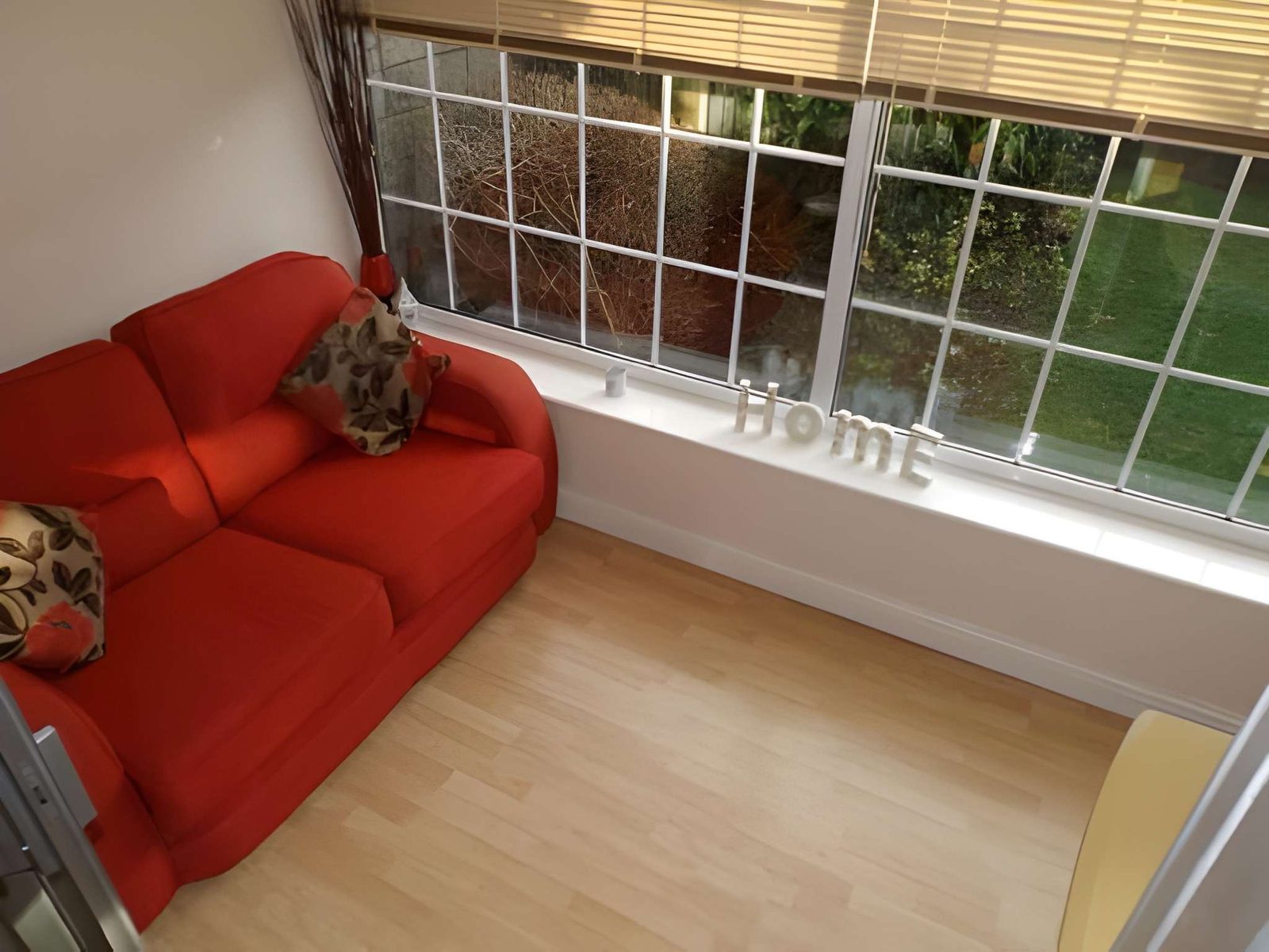 Conservatory with sofa, looking onto the garden