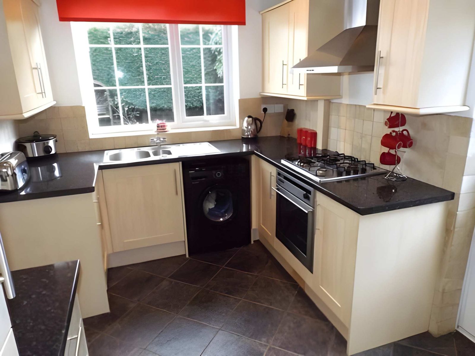 Kitchen with sink under the window, gas hob and built-in oven