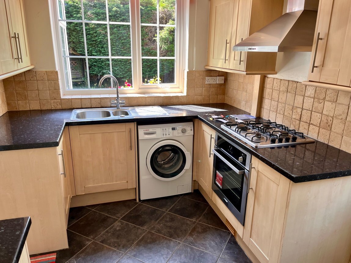 Kitchen with sink under the window, gas hob and built-in oven